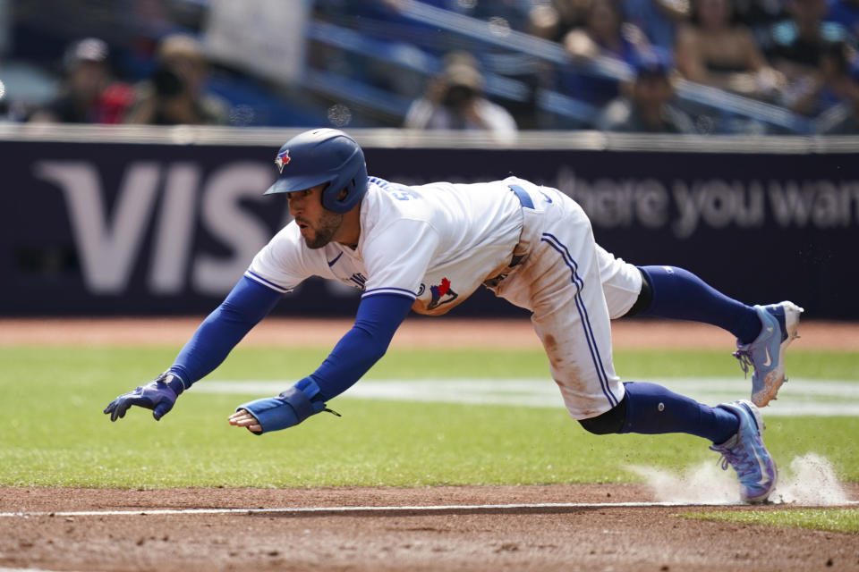 Toronto Blue Jays' George Springer (4) dives for home plate during the fifth inning of a baseball game against the Minnesota Twins in Toronto, Saturday, June 10, 2023. (Arlyn McAdorey/The Canadian Press via AP)