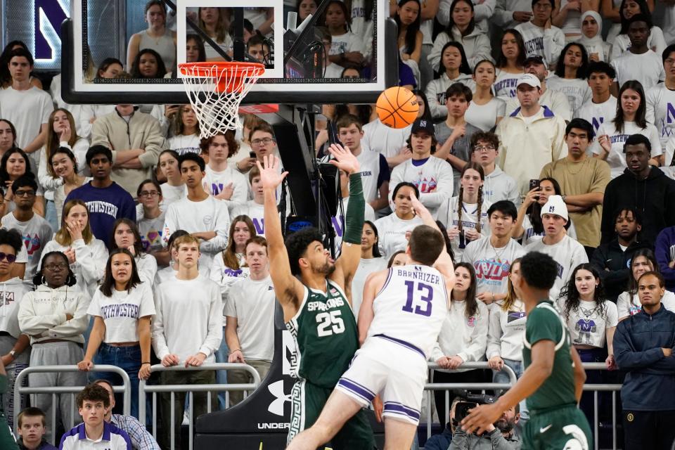 Northwestern Wildcats guard Brooks Barnhizer (13) scores over Michigan State Spartans forward Malik Hall (25) during the first half at Welsh-Ryan Arena in Evanston, Illinois, on Sunday, Jan. 7, 2024.