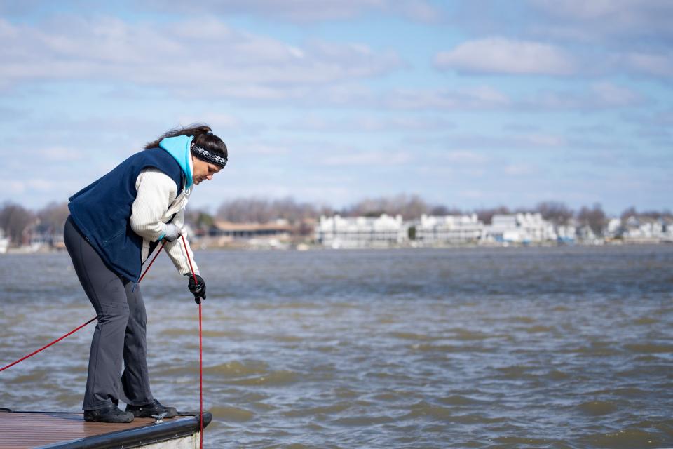 Angel Carbone pulls in her magnet Tuesday, March 7, 2023, after casting out while fishing for objects hidden under the surface at Morse Beach at Morse Reservoir in Noblesville, Ind. She hauls in unexpected treasures from a Casio watch to foldable lawn chairs, all while helping rid Indiana waterways of trash and toxic metals.