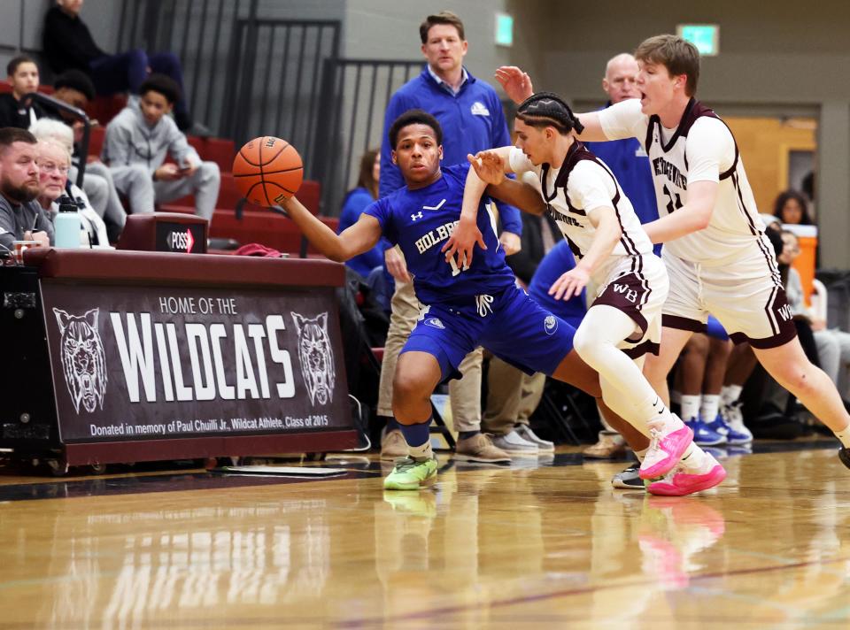 Holbrook's Darkari Dingle passes the ball next to West Bridgewater defenders from left, Armani Lloret during a game on Thursday, Feb. 1, 2024.