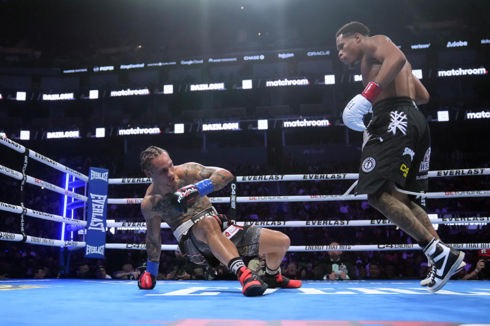 Regis Prograis, left, falls down next to Devin Haney during the WBC super lightweight title boxing bout Saturday, Dec. 9, 2023, in San Francisco. (AP Photo/Jeff Chiu)