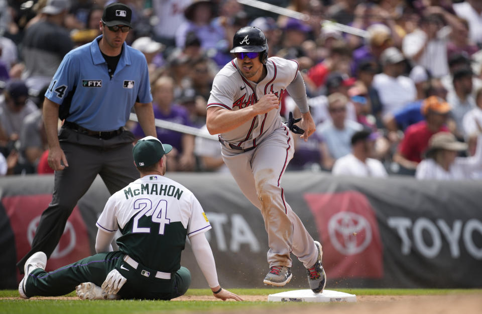 Atlanta Braves' Adam Duvall, right, heads to home plate to score on an error after Colorado Rockies third baseman Ryan McMahon (24) missed a throw by catcher Brian Serven in the fifth inning of a baseball game Sunday, June 5, 2022, in Denver. (AP Photo/David Zalubowski)