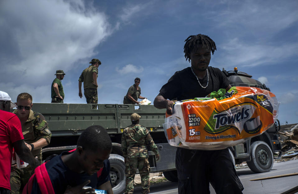 Locals receive help from Dutch soldiers in the aftermath of Hurricane Dorian in Abaco, Bahamas, Monday, Sept. 16, 2019. Dorian hit the northern Bahamas on Sept. 1, with sustained winds of 185 mph (295 kph), unleashing flooding that reached up to 25 feet (8 meters) in some areas. (AP Photo/Ramon Espinosa)