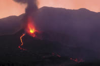 Lava flows from a volcano on the Canary island of La Palma, Spain in the early hours of Sunday Sept. 26, 2021. A volcano in Spain's Canary Islands is keeping nerves on edge several days since it erupted, producing loud explosions, a huge ash cloud and cracking open a new fissure that spewed out more fiery molten rock. (AP Photo/Daniel Roca)