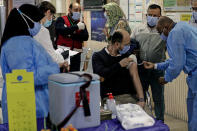 An Iraqi health personnel receives a Sinopharm coronavirus vaccine at a clinic in Basra, Iraq, Wednesday, March 3, 2021. (AP Photo/Nabil al-Jurani)