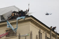 A police helicopter flies over rioting inmates protesting from the roof of Villa Devoto prison in Buenos Aires, Argentina, April 24, 2020. Inmates complain authorities are not doing enough to prevent the spread of coronavirus inside the prison. (AP Photo/Natacha Pisarenko)