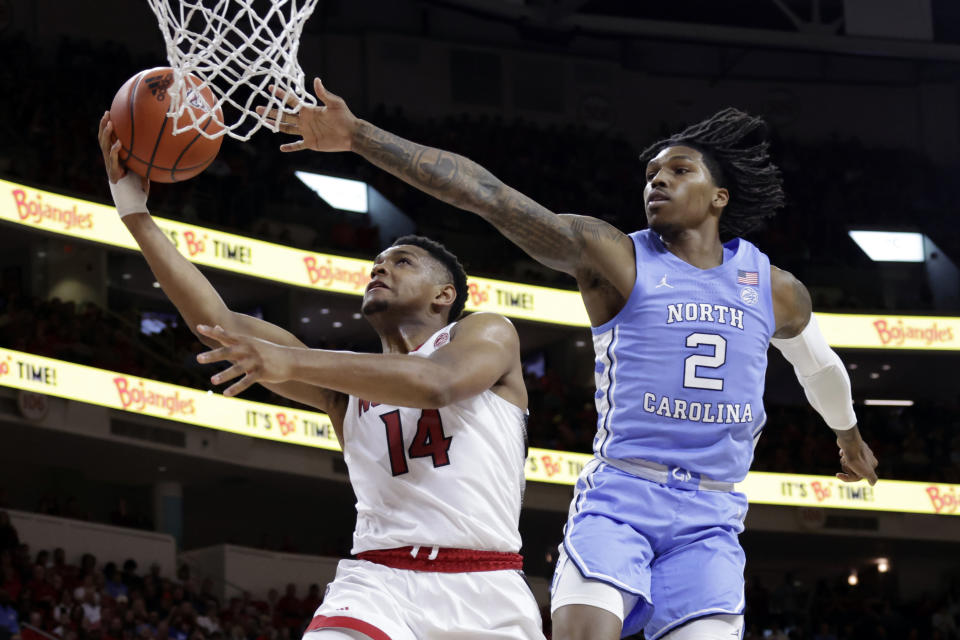 North Carolina State guard Casey Morsell (14) drives past North Carolina guard Caleb Love (2) during the second half of an NCAA college basketball game Sunday, Feb. 19, 2023, in Raleigh, N.C. (AP Photo/Chris Seward)