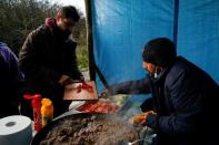 Wider Image: En un campo de inmigrantes en Francia, un hombre vende sándwiches para pagarle a los traficantes