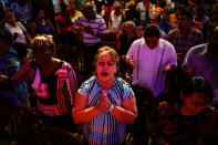 People react during a religious ceremony where victims of the Boeing 737 plane crash were remembered at a church in Havana, Cuba, May 20, 2018. REUTERS/Alexandre Meneghini