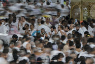 In this photo taken with low shutter speed, Muslim pilgrims pray as others circumambulate around the Kaaba, the cubic building at the Grand Mosque, in Mecca, Saudi Arabia, Wednesday, July 6, 2022. Muslim pilgrims are converging on Saudi Arabia's holy city of Mecca for the largest hajj since the coronavirus pandemic severely curtailed access to one of Islam's five pillars. (AP Photo/Amr Nabil)