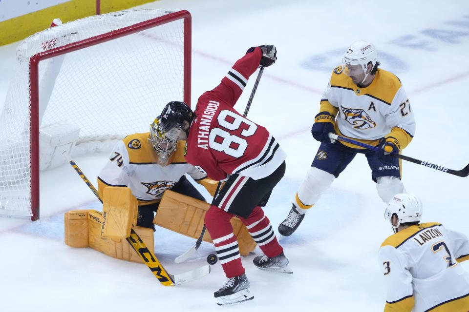 Chicago Blackhawks' Andreas Athanasiou (89) is unable to get a rebound shot off a save by Nashville Predators goaltender Juuse Saros, left, as Predators' Jeremy Lauzon (3) and Ryan McDonagh watch during the third period of an NHL hockey game Saturday, March 4, 2023, in Chicago. (AP Photo/Charles Rex Arbogast)