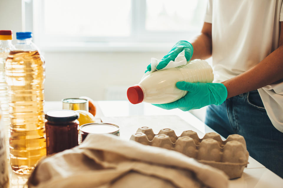 Sanitizing procedure of products bought online during the quarantine by a caucasian person wearing gloves