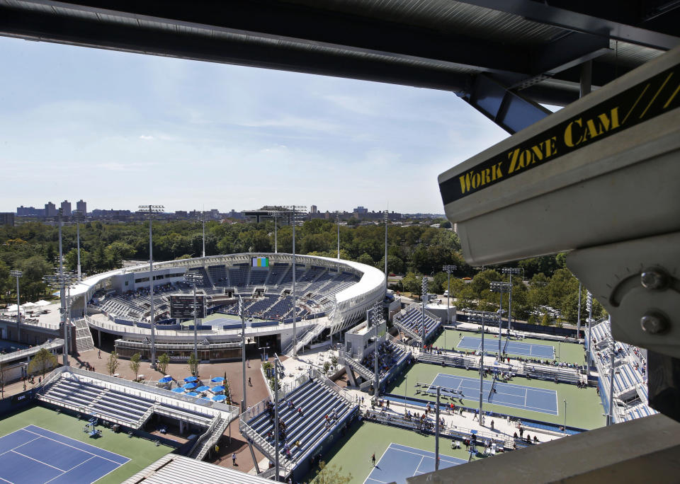 FILE - In this Aug. 24, 2016, file photo, a closed circuit construction camera peers out at the Grandstand stadium during qualifying rounds at the Billie Jean King National Tennis Center in New York. As teams prepare to welcome back fans, there are serious legal and ethical questions that must be answered. (AP Photo/Kathy Willens, File)