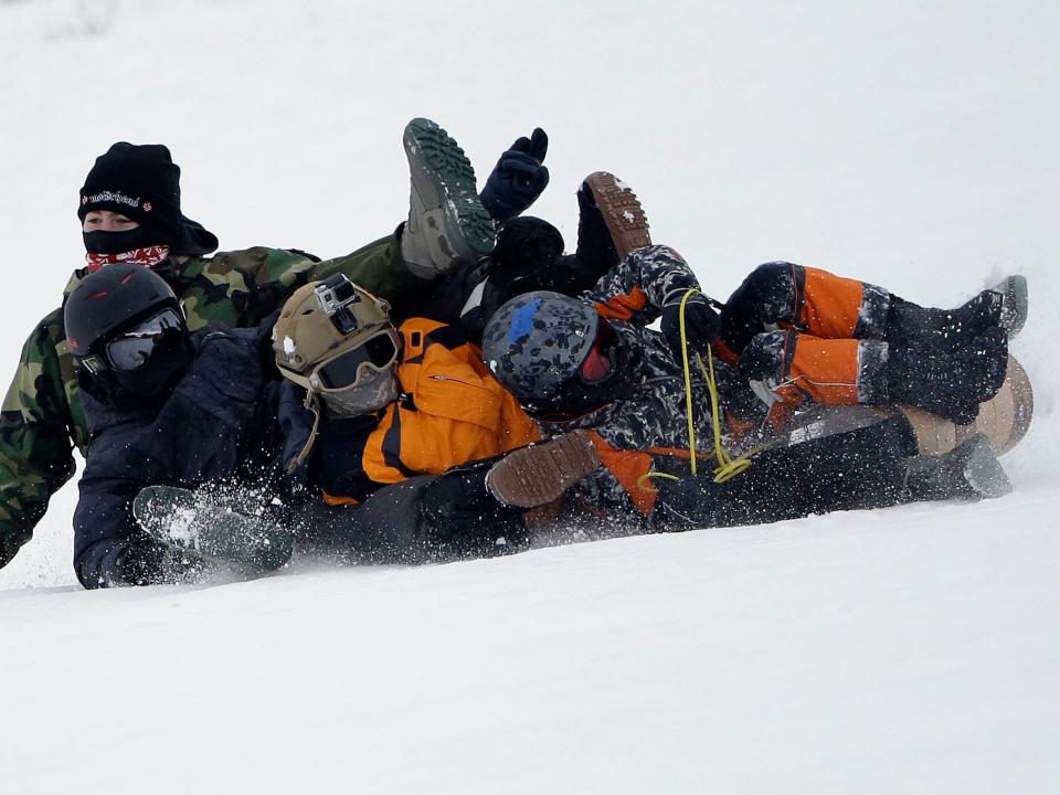 Four boys fall over as they sled down a snowy hill near Lake Tahoe