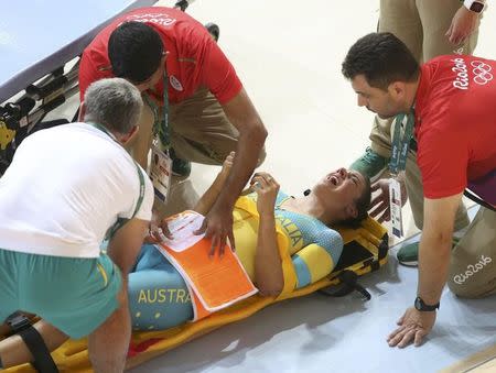 2016 Rio Olympics - Cycling Track - Preliminary - Team training - Rio Olympic Velodrome - Rio de Janeiro, Brazil - 08/08/2016. Australia's (AUS) women's team member Melissa Hoskins is aided after a crash during a practice session. REUTERS/Eric Gaillard