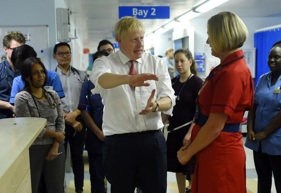 Britain's Prime Minister Boris Johnson speaks to health professionals as he visits Watford General hospital, England, Monday Oct. 7, 2019. The UK government has pledged billions for new hospital projects across England under plans devised up by Health Secretary Matt Hancock. (Peter Summers/Pool via AP)