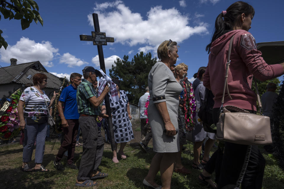 Relatives and friends of 35-year-old Anna Protsenko, who was killed in a Russian rocket attack, walk to a cemetery for her burial during her funeral procession, on the outskirts of Pokrovsk, eastern Ukraine, Monday, July 18, 2022. (AP Photo/Nariman El-Mofty)