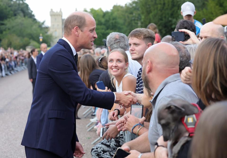 WINDSOR, ENGLAND - SEPTEMBER 10: Prince William, Prince of Wales shakes hands with members of the public on the Long walk at Windsor Castle on September 10, 2022 in Windsor, England. Crowds have gathered and tributes left at the gates of Windsor Castle to Queen Elizabeth II, who died at Balmoral Castle on 8 September, 2022. (Photo by Chris Jackson - WPA Pool/Getty Images)