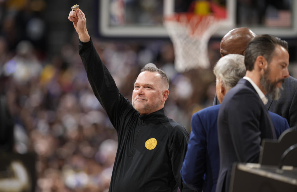 Denver Nuggets coach Michael Malone holds up his NBA championship ring during a ceremony before the team's NBA basketball game against the Los Angeles Lakers on Tuesday, Oct. 24, 2023, in Denver. (AP Photo/David Zalubowski)