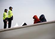 Family members of a missing passenger onboard South Korean ferry Sewol, which capsized on Wednesday, look at the sea as they wait for news from rescue and salvage teams at a port in Jindo April 22, 2014. REUTERS/Kim Kyung-Hoon