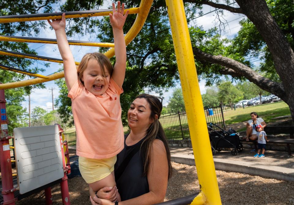 Olivia Zeiher, 5, makes it to the end of the monkey bars with help from her mom, Kelly Zeiher, at the Zilker Park playscape. University of Texas researchers have been studying how temperatures affect children's play.