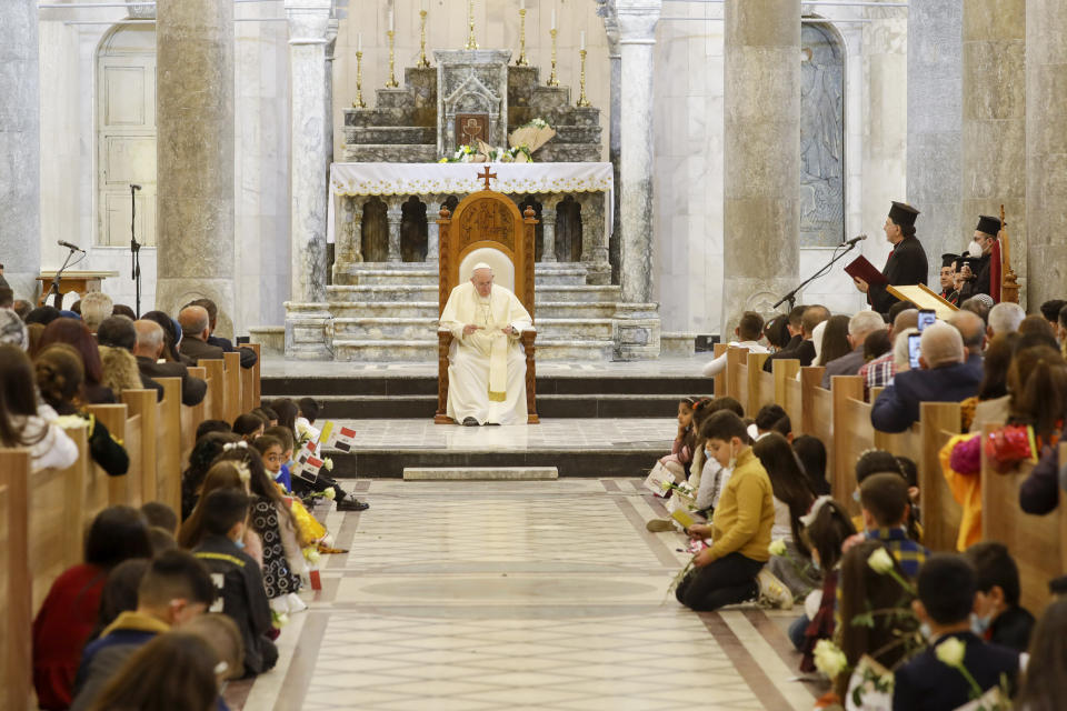 Pope Francis listens to Syriac Catholic Patriarch Ignatius Joseph III Yonan, right, delivering his welcome speech during a meeting with the Qaraqosh community at the Church of the Immaculate Conception, in Qaraqosh, Iraq, Sunday, March 7, 2021, The small Christian community returned to Qaraqosh after the war where they rebuilt their church that was used as a firing range by IS. (AP Photo/Andrew Medichini)