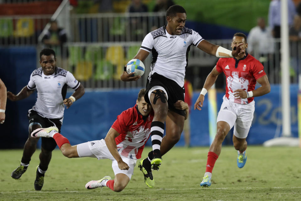 FILE - In this Aug. 11, 2016, file photo, Viliame Mata of Fiji evades a tackle during the gold medal mens rugby sevens match against Britain at the 2016 Summer Olympics in Rio de Janeiro, Brazil. It was rugby in fast forward and it generated millions of new fans across the world. Rugby sevens made its Olympic debut in Rio de Janeiro in 2016 bringing all the usual hard-hitting tackles, collisions and swerving runs but leaving out the slow-mo elements of the traditional 15-a-side game. (AP Photo/Robert F. Bukaty, File)