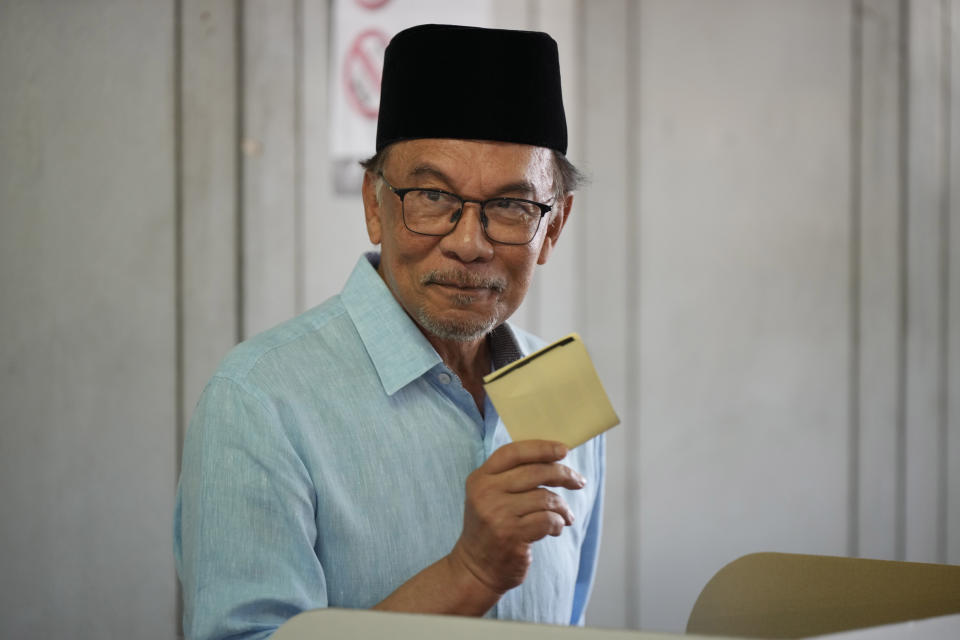 Malaysian opposition leader Anwar Ibrahim shows his ballot during the election at a polling station in Seberang Perai, Penang state, Malaysia, Saturday, Nov. 19, 2022. Malaysians began casting ballots Saturday in a tightly contested national election that will determine whether the country's longest-ruling coalition can make a comeback after its electoral defeat four years ago. (AP Photo/Vincent Thian)