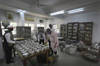 Volunteers pack prasad or devotional offering made to god, typically consisting of food that is later shared among devotees, to be sent to the homes of devotees in an effort to prevent large gatherings at the temple during the Durga Puja festival in New Delhi, India, Thursday, Oct. 22, 2020. Most of the festival festivities are being scaled down following the health officials warning about the potential for the coronavirus to spread during the religious festival season, which is marked by huge gatherings in temples and shopping districts.(AP Photo/Manish Swarup)