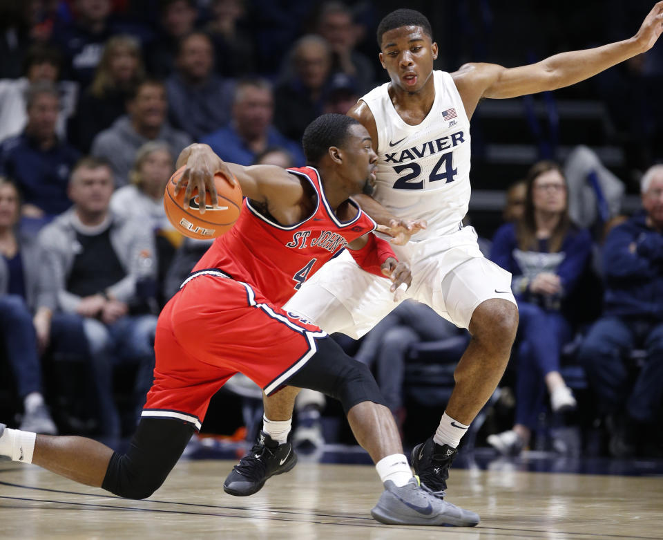 St. John's guard Greg Williams Jr., left, drives against Xavier guard KyKy Tandy (24) during the first half of an NCAA college basketball game, Sunday, Jan. 5, 2020, in Cincinnati. (AP Photo/Gary Landers)