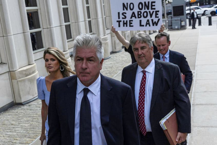 Trump's legal team walking in front of protestor.