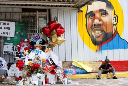 FILE PHOTO: A boy sits next to a makeshift memorial outside the Triple S Food Mart where Alton Sterling was fatally shot by police in Baton Rouge, Louisiana, U.S. July 7, 2016. REUTERS/Jonathan Bachman/File Photo