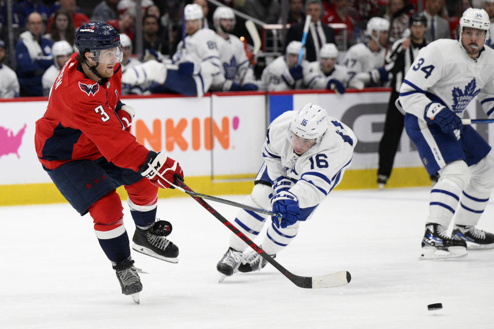 Washington Capitals defenseman Nick Jensen (3) passes the puck against Toronto Maple Leafs right wing Mitchell Marner (16) during the second period of an NHL hockey game, Sunday, April 24, 2022, in Washington. (AP Photo/Nick Wass)