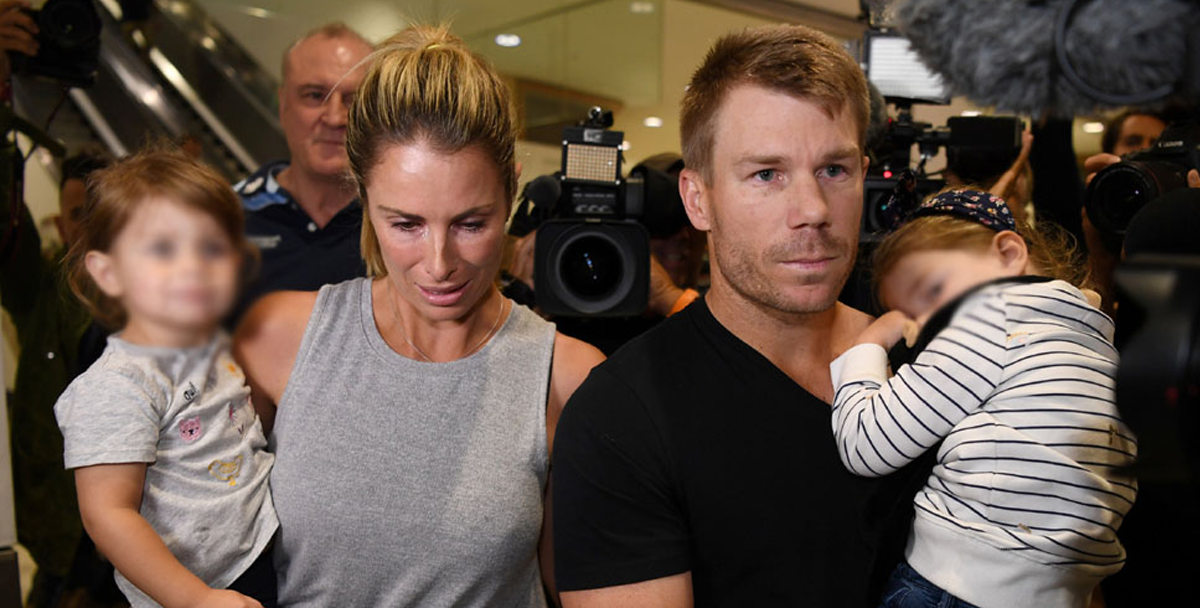 Candice and David Warner brave the media scrum at Sydney Airport.