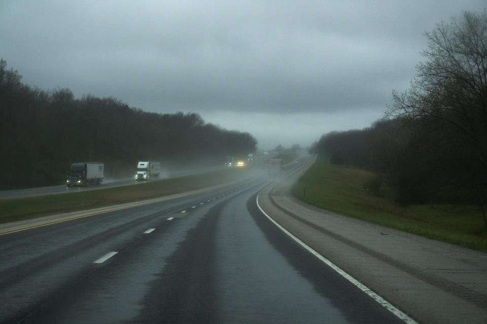 In this April 4, 2020, photo, trucks roll in the rain on eastbound Interstate 70 near Altamont, Ill. During the coronavirus outbreak, truckers work to get us what we need. (AP Photo/Carolyn Kaster)