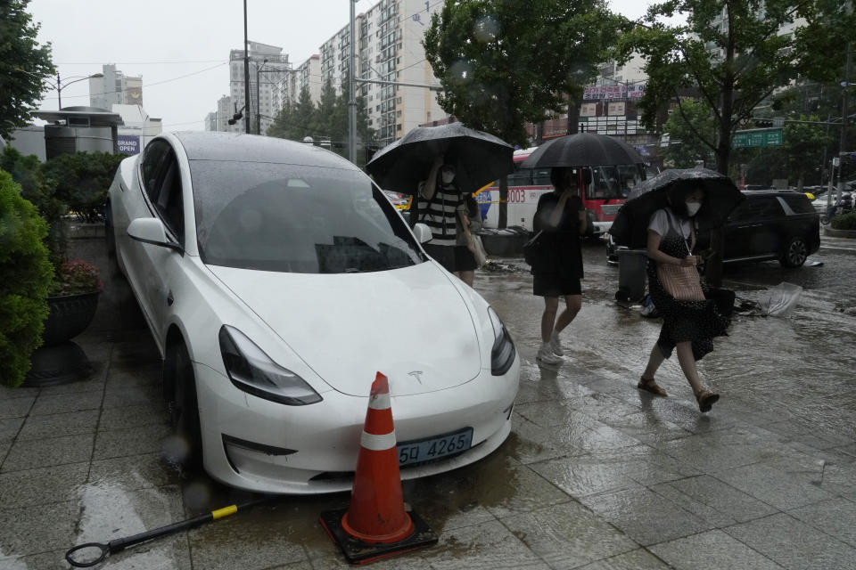 A vehicle sits damaged on the sidewalk after floating in heavy rainfall in Seoul, South Korea, Tuesday, Aug. 9, 2022. Heavy rains drenched South Korea's capital region, turning the streets of Seoul's affluent Gangnam district into a river, leaving submerged vehicles and overwhelming public transport systems. (AP Photo/Ahn Young-joon)