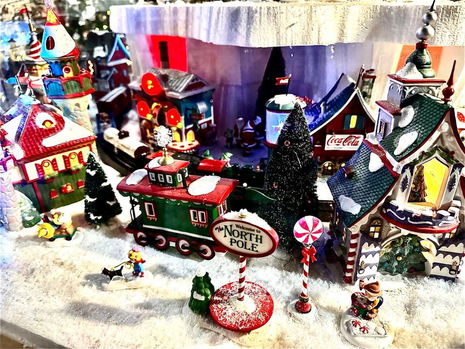 A train rolls past the North Pole station in this village scene at Ku-Tips Nursery & Gift Shop in Farmington.