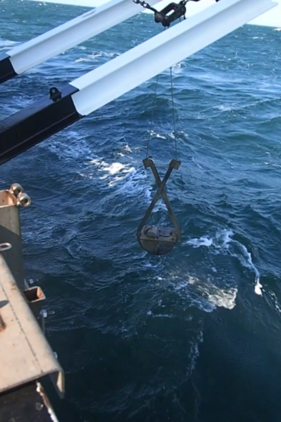 A grab bucket being lifted out of the sea after having been used to extract a sediment sample from the seabed. It was in just such sediment samples that the British and Belgian archaeologists, on the Belgian research vessel, found the two flint artefacts (© Simon Fitch, University of Bradford)