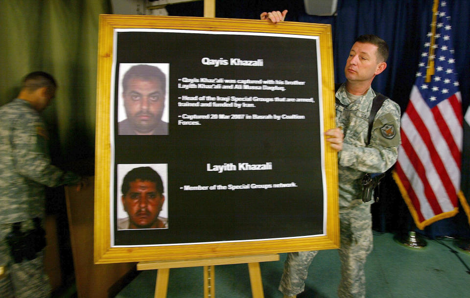 A US officer places a board showing a breakaway Shiite group leader Qais al-Kazaali, a former spokesman for cleric Muqtada al-Sadr,and his  brother Ali al-Khazaali before a press conference in Baghdad, Iraq, July 2, 2007.  Tehran's elite Quds force helped militants carry out a January attack in Karbala in which five Americans were killed. (Photo: Wathiq Khuzaie/AP)