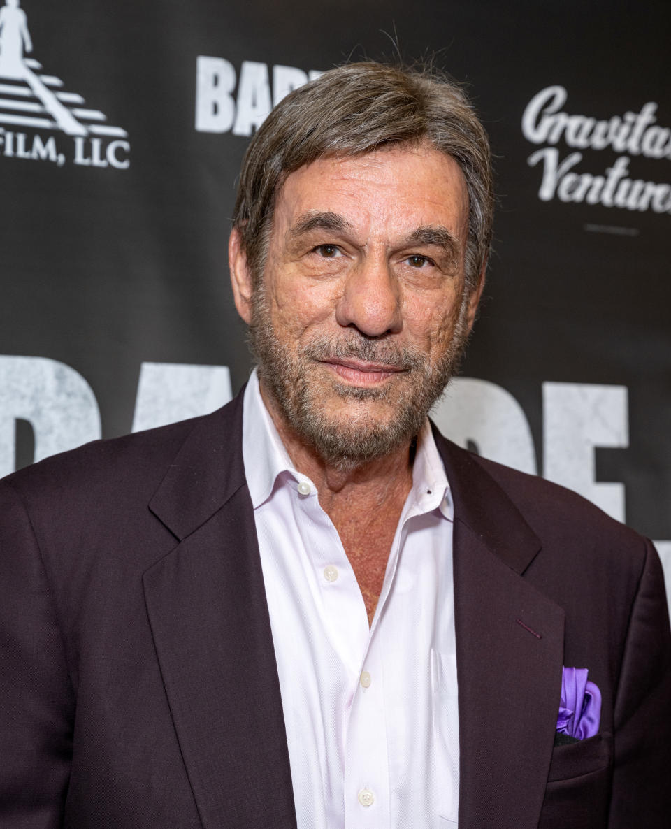 Man in a suit with a pocket square at a premiere event