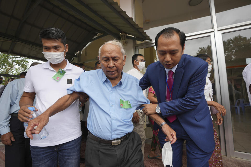 Chum Mey, center, former S-21 prison survivor, is helped by court officials as he leaves the courtroom after the verdict is announced for Khieu Samphan, former Khmer Rouge head of state, at the U.N.-backed war crimes tribunal in Phnom Penh, Cambodia, Thursday, Sept. 22, 2022. The tribunal rejected the appeal of a genocide conviction for the communist group's last surviving leader in what is expected to be the special court's last session. (AP Photo/Heng Sinith)