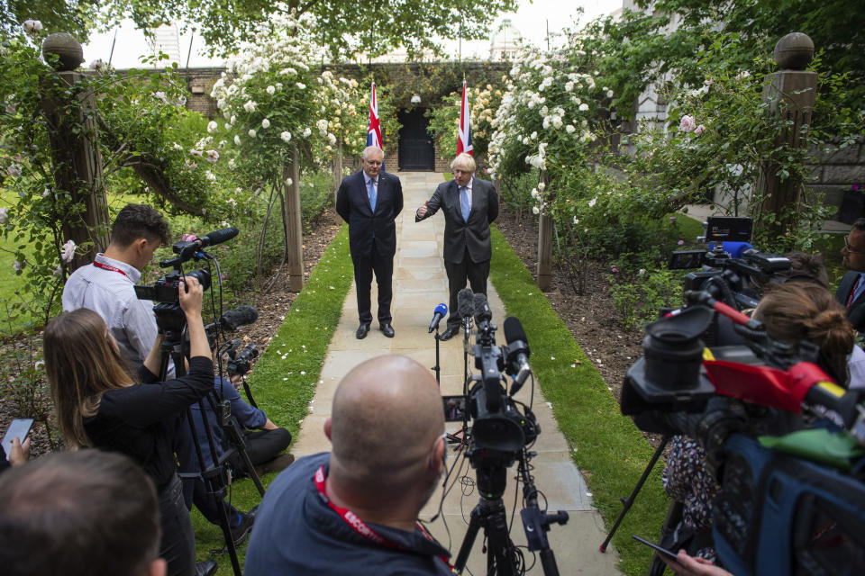 Britain's Prime Minister Boris Johnson,centre right, and Australian Prime Minister Scott Morrison pose for the media, after their meeting, in the garden of 10 Downing Streeet, in London, Tuesday June 15, 2021. Britain and Australia have agreed on a free trade deal that will be released later Tuesday, Australian Trade Minister Dan Tehan said. (Dominic Lipinski/Pool Photo via AP)