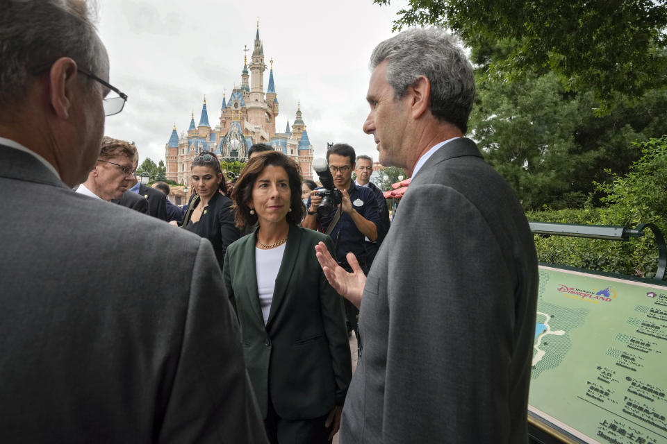 U.S. Commerce Secretary Gina Raimondo, center, chats with officials as she tours the Shanghai Disneyland in Shanghai, China, Wednesday, Aug. 30, 2023. (AP Photo/Andy Wong, Pool)