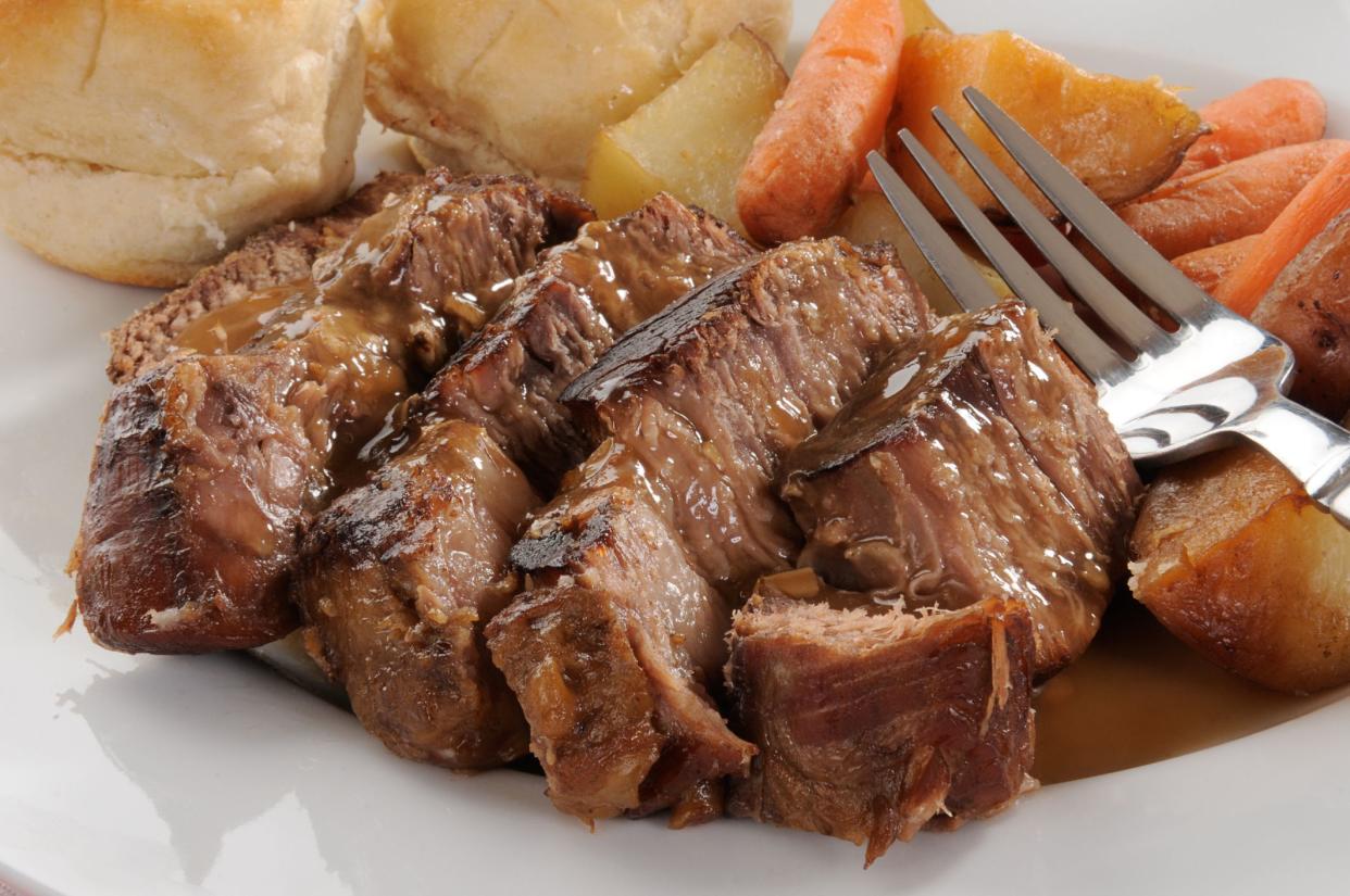 Closeup of a plate of beef pot roast with mushroom gravy