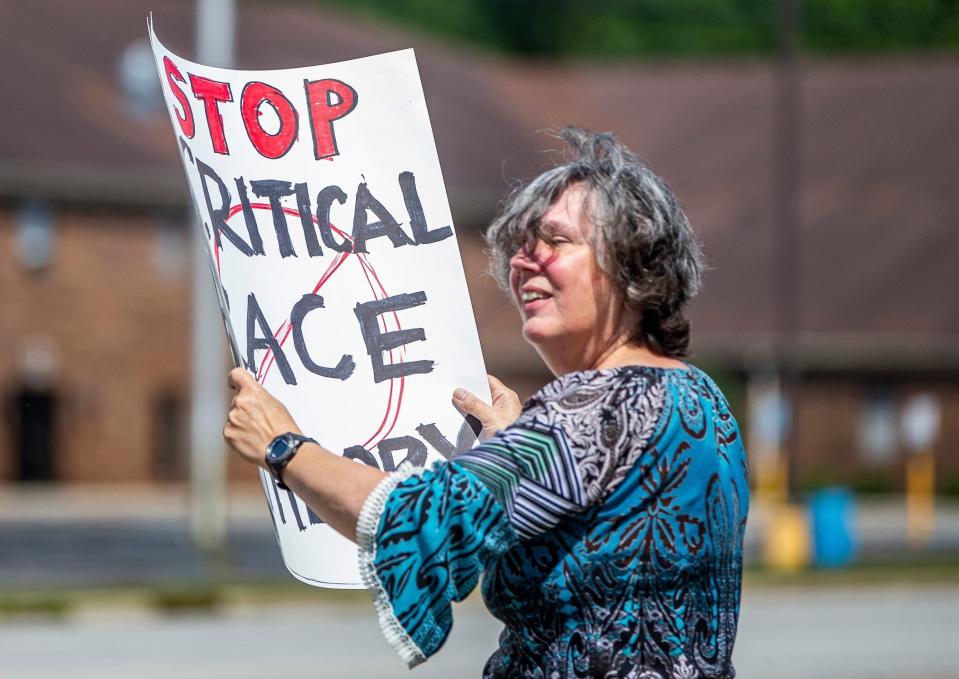 A woman holds a sign that says "Stop critical race theory" during an anti-mask demonstration in Mishawaka, Ind., on July 30. [ASSOCIATED PRESS/FILE]