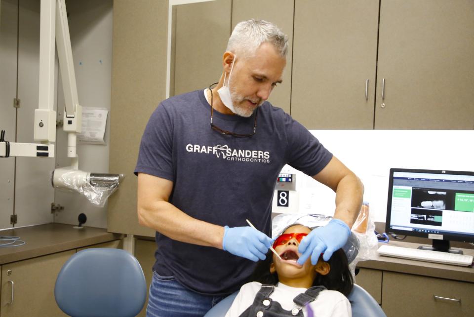 Orthodontist Derek Graff examines a patient Friday, Feb. 2 during the 21st annual Give Kids a Smile Day free dental clinic at the Health and Human Performance Center at San Juan College in Farmington.