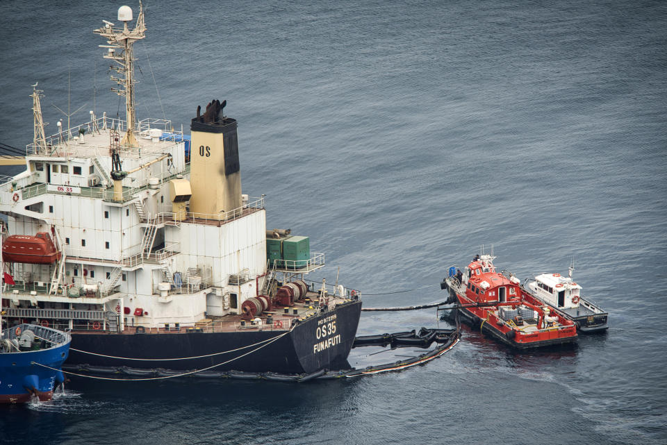 Fuel is transferred by a pipe to a small orange boat as a precaution from the stricken Tuvalu-registered OS 35 cargo ship that collided with a liquid natural gas carrier in the bay of Gibraltar last Monday in Gibraltar, Thursday, Sept. 1, 2022. Gibraltar authorities say that a small amount of heavy fuel oil has leaked from a bulk carrier ship stranded since colliding Monday with another ship near the Bay of Gibraltar. A government spokesman said that the situation was under control and the cargo ship was not in danger. He said there has been no environmental impact so far. (AP Photo/Marcos Moreno)