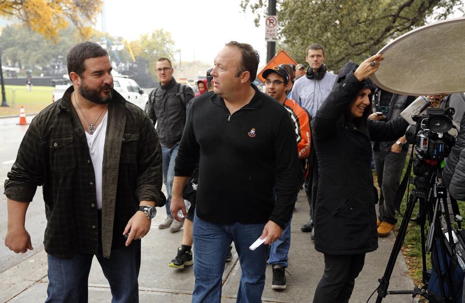 Conspiracy theorist, radio talkshow host and Infowars.net founder Alex Jones talks to a fan as he walks through Dealey Plaza in Dallas