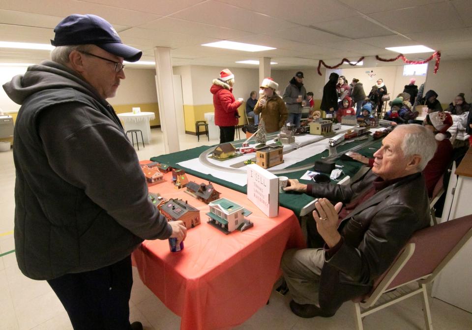Ray Pluff, left, and David Thompson, both from Fowlerville, talk trains at Thompson's layout displayed in the basement of the First Baptist Church during the Christmas in the 'Ville event Saturday, Dec. 4, 2021.