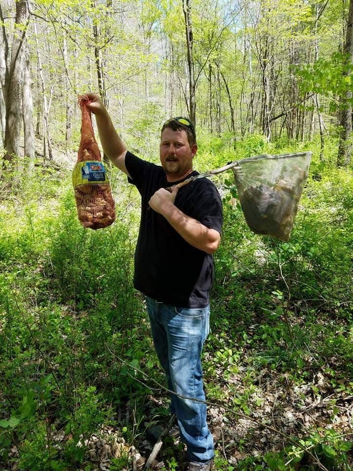 Andrew McCloud holds up his haul of morel mushrooms. The fungi grows in Indiana for a short period in early spring, and foragers from across the state head into the woods to search for the flavorful morel.